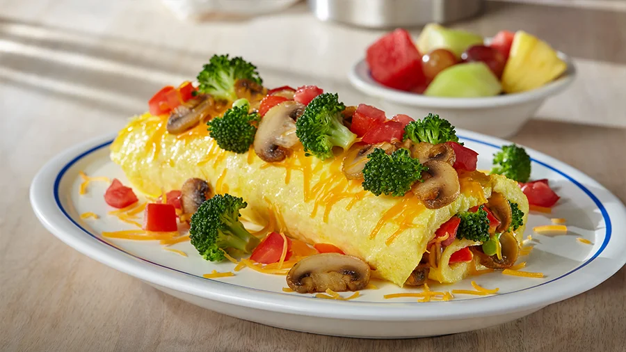 Vegetable omelette with broccoli, mushrooms, tomatoes and cheese, with fresh fruit