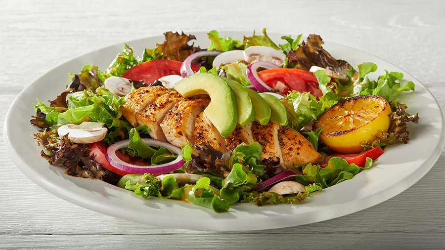 Grilled chicken salad with avocado, tomatoes, red onion and citrus