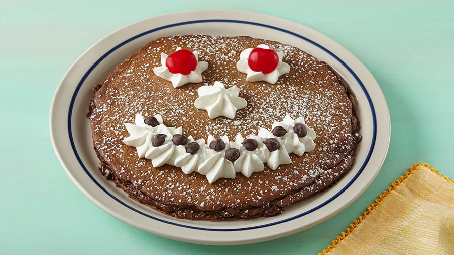 Kids' chocolate chip Funny Face pancake with a whipped-cream smile
