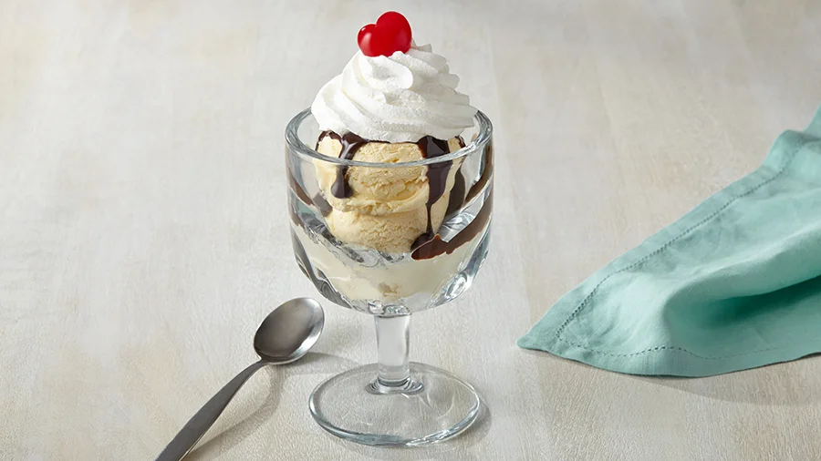 Ice cream sundae with chocolate sauce, whipped cream and a cherry